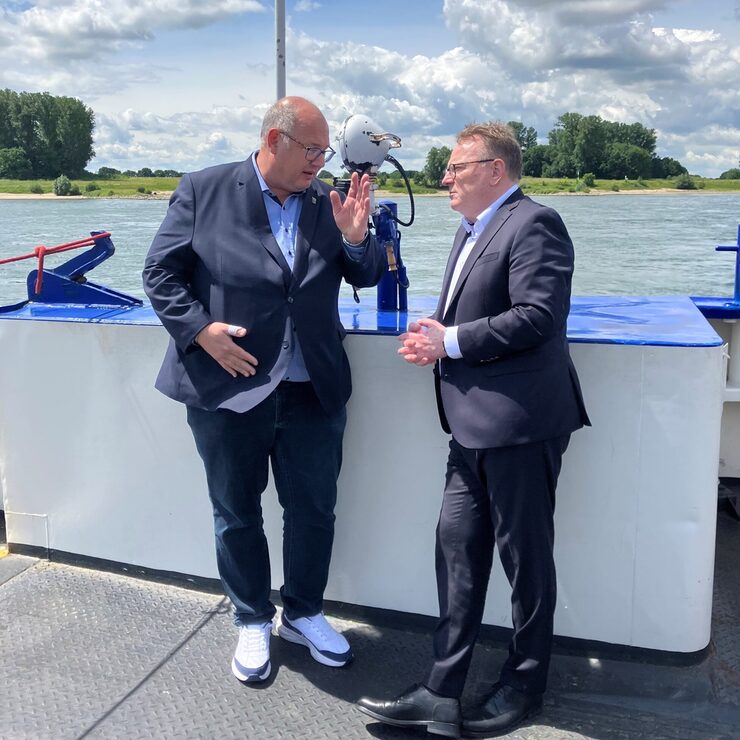 Oberbürgermeister Stefan Hebbel (l.) und Oberbürgermeister Torsten Burmester (r.) beim Austausch während der Überfahrt auf der Fähre "St. Michael" von Leverkusen-Hitdorf nach Köln-Langel