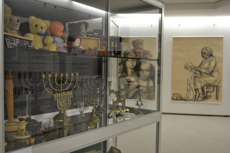 Blick in einen Teil der Ausstellung mit Vitrine von Erinnerungsstücken und Gemälden