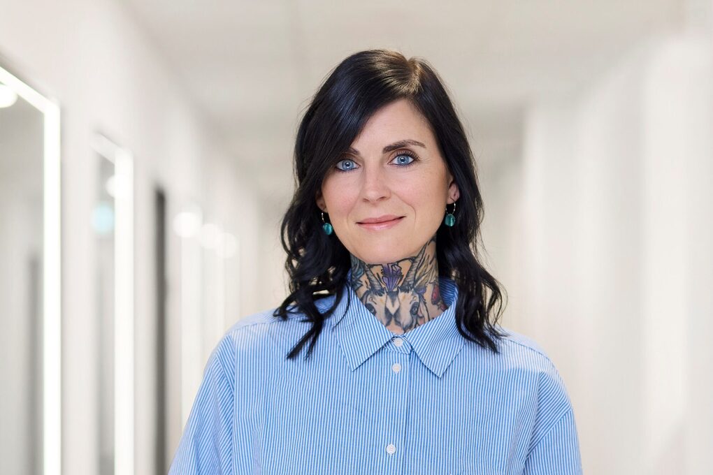 Eine Frau steht im Flur und hält ein Tablet in der Hand