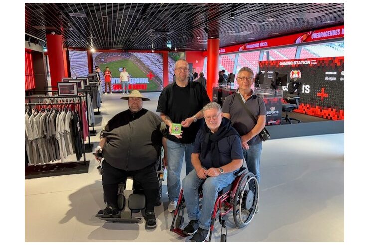 Vier Personen befinden sich mit dem Gütesiegel Barrierefrei in der Fanwelt der BayArena