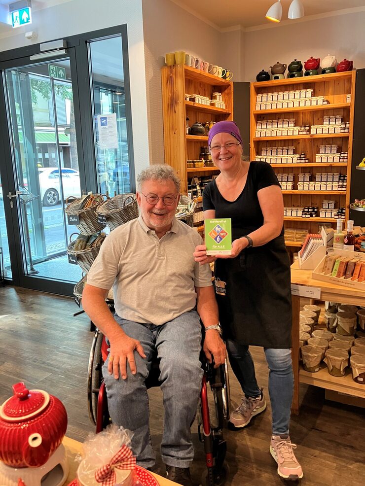 Zwei Personen stehen mit dem Gütesiegel Barrierefrei im Feinkochtopf Leverkusen