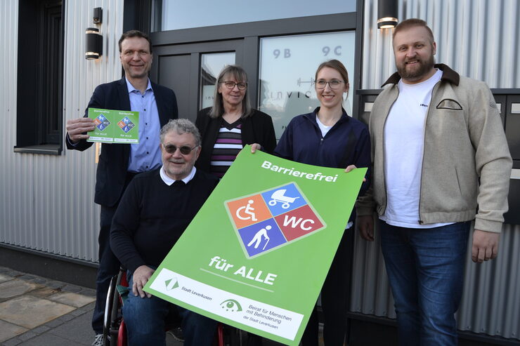 Fünf Personen stehen mit dem Gütesiegel Barrierefrei vor Invictus Physiotherapie