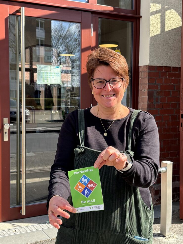 Eine Frau hält das Barrierefrei-Siegel in der Hand